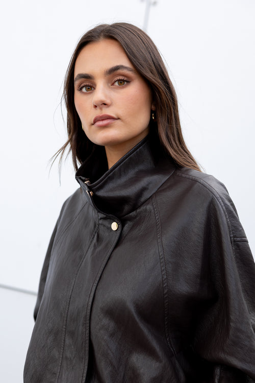 Woman wearing a black jacket against a white background