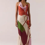 Woman wearing a colorful dress with abstract patterns on a plain background