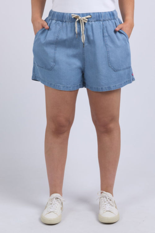 Woman wearing chambray denim shorts and white tank