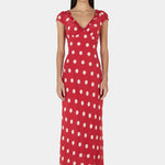 Woman wearing a red polka dot dress on a white background