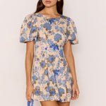 model wears a blue floral mini dress