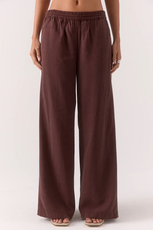 Brown wide-leg pants worn by a person on a white background