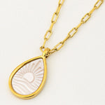 Gold necklace with a teardrop-shaped pendant on a white background