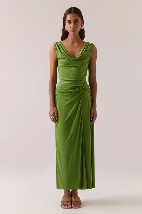Woman wearing a green dress against a plain background