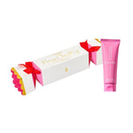 Pink tube of lip balm and white box with red bow on a white background
