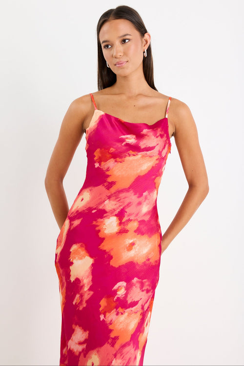 Woman wearing a pink and orange tie-dye dress on a white background