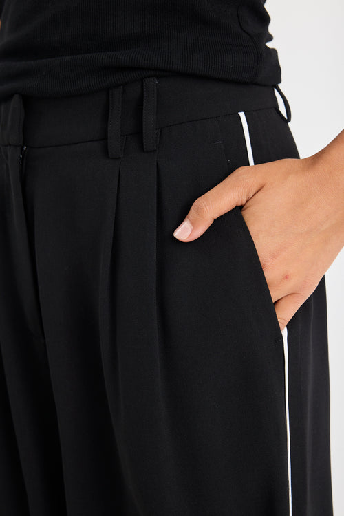 Black pants with a hand in the pocket on a white background