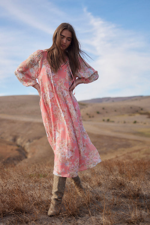 model wears a pink floral midi dress