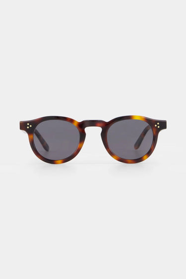 Sunglasses with tortoiseshell frame and dark lenses on a white background