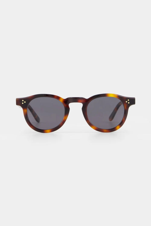 Sunglasses with tortoiseshell frame and dark lenses on a white background