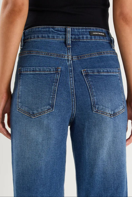 Blue jeans being worn with a plain background