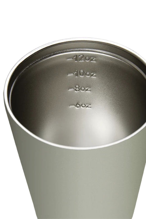 Stainless steel tumbler with measurement markings on a white background