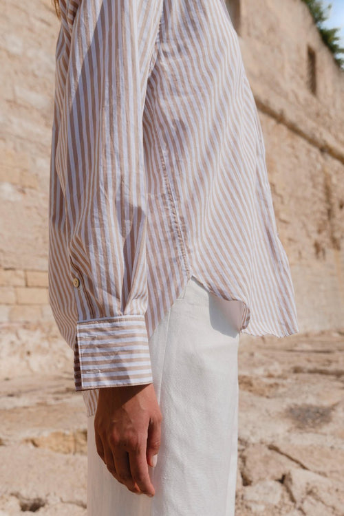 Model wears a stripe white and tan shirt 