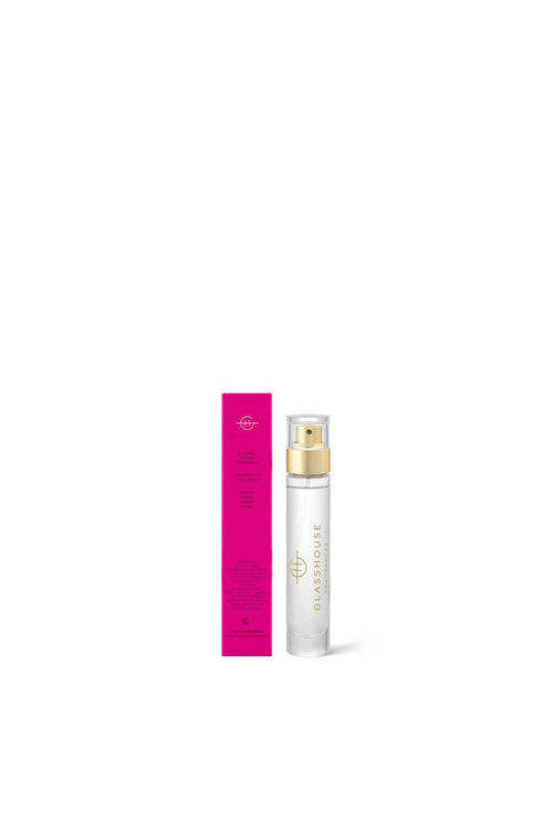 White spray bottle with gold cap and pink box on a white background