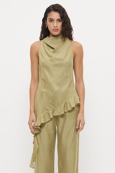 A model wearing a sage green two-piece set consisting of a sleeveless draped top with ruffles and matching wide-leg pants, paired with black sandals, against a plain white studio background.