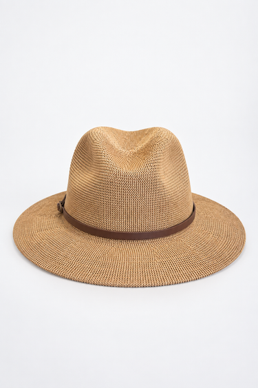 A woven straw fedora hat in a light tan color with a dark brown band, photographed from the side against a plain white background.