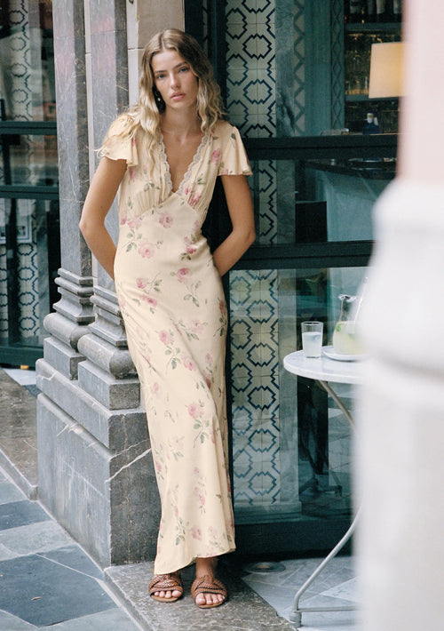 model wears a cream floral dress