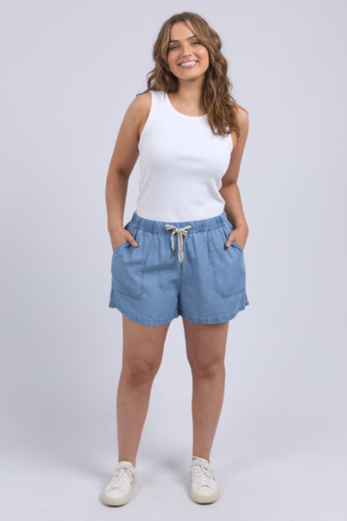 Woman wearing chambray denim shorts and white tank