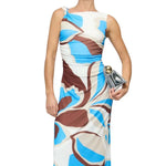 Woman wearing a patterned dress holding a clutch on a white background