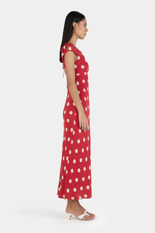 Woman wearing a red polka dot dress on a white background