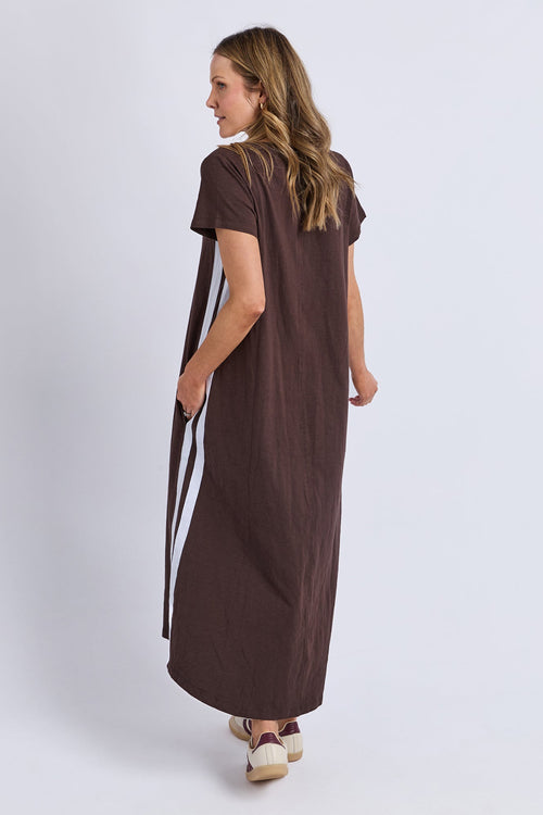 Woman wearing a brown dress with a long ribbon on a white background