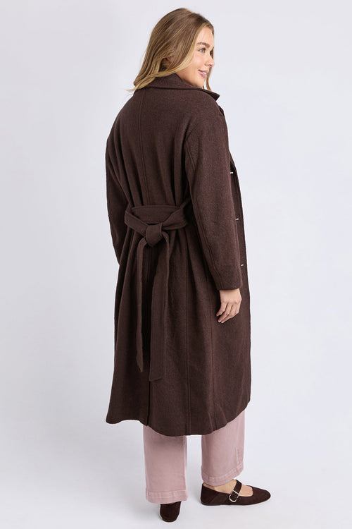 Woman wearing a brown coat on a white background