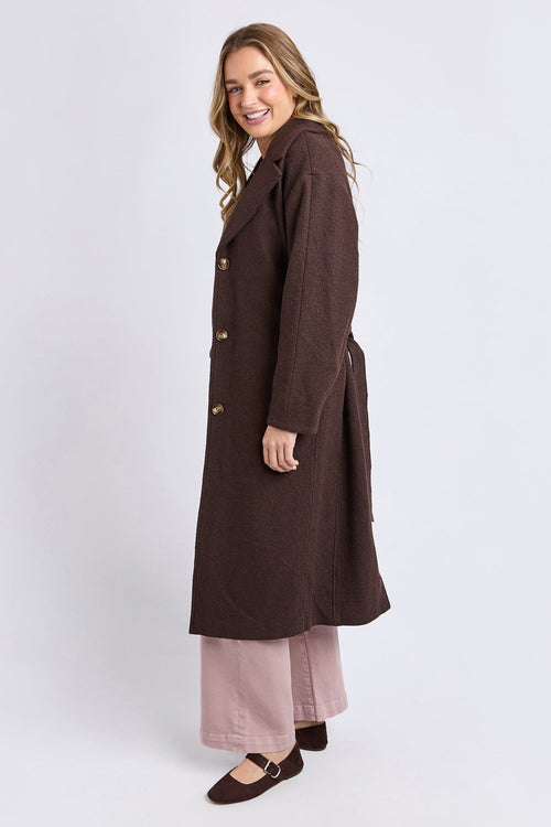 Woman wearing a long brown coat on a white background