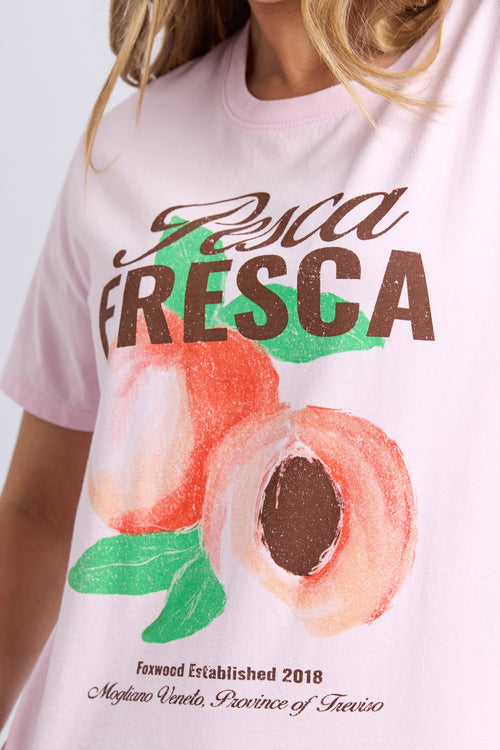 Woman wears a pink printed top and blue shorts