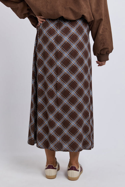 Person wearing a brown plaid skirt on a white background