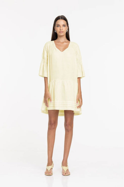 Woman wearing a light yellow dress on a white background