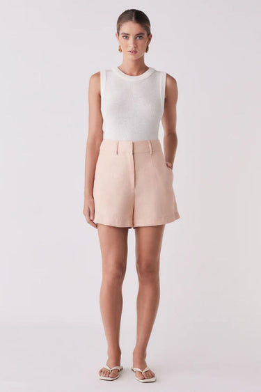 Woman wearing a pink short and white tank top