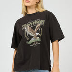 Person wearing a black t-shirt with an eagle graphic and text on a plain background