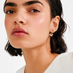 Woman wearing a white top with a plain background