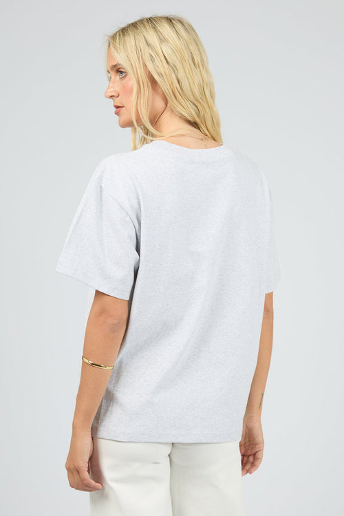 Person wearing a plain white t-shirt on a light gray background