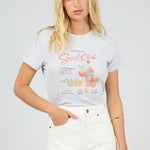 Woman wearing a graphic t-shirt with text and graphics on a plain background