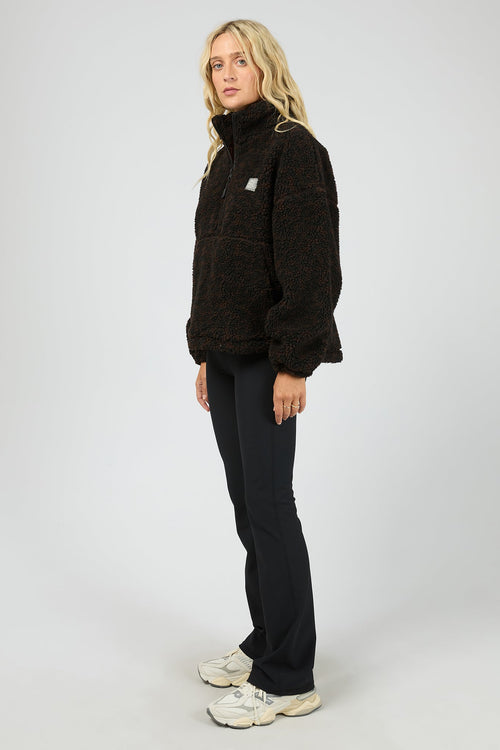 Person wearing a black pullover with a logo on a white background