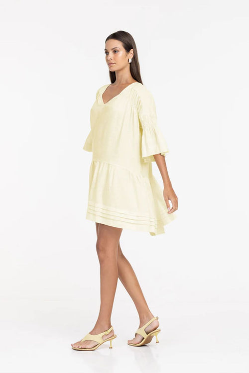 Woman wearing a light yellow dress on a white background