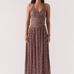 Woman wearing a brown and blue polka dot ruched maxi dress