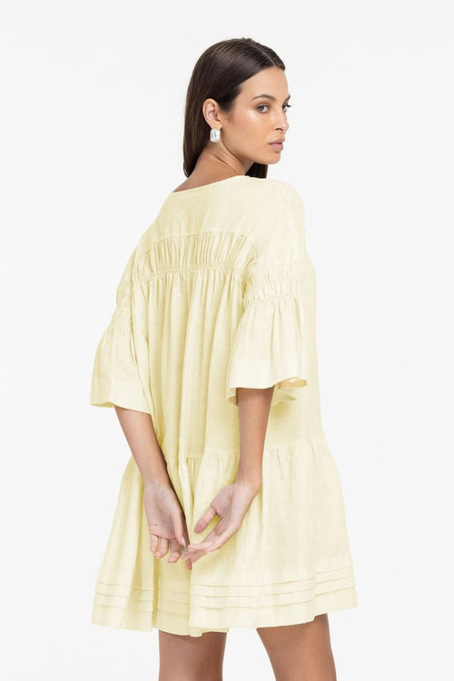 Woman wearing a light yellow dress on a white background