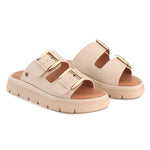 A pair of beige double-strap platform slide sandals with gold-tone buckle details, shown against a plain white background.