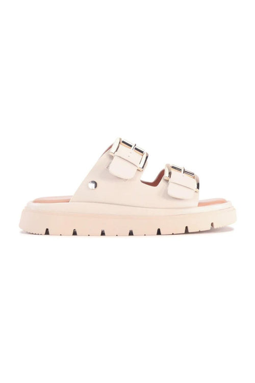 A single light beige double-strap slide sandal with metallic silver buckles and a chunky sole, shown from a side profile on a white background.