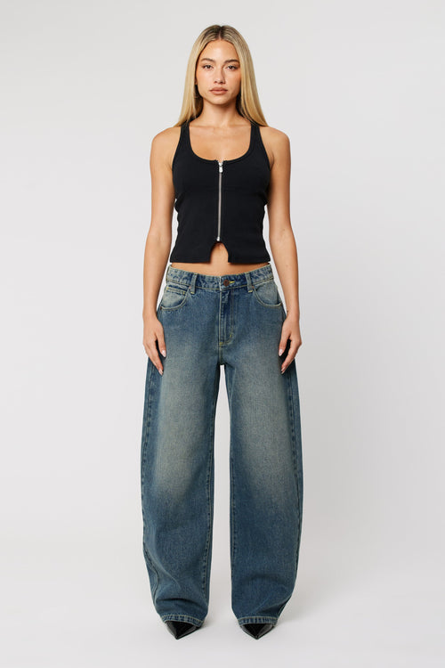 Woman wearing dark wash denim blue jeans with wide leg 