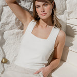 model wearing a white tank top and biege pant