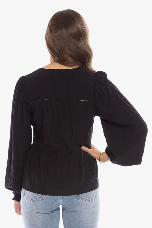 model in long sleeve black v neck blouse