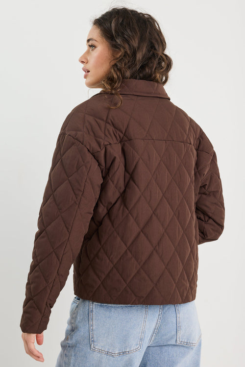 Person wearing a brown quilted jacket on a white background
col_pattern