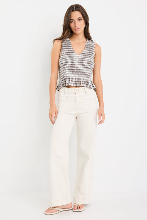 Chocolate gingham sleeveless shell top with frill hem, styled with cream jeans
