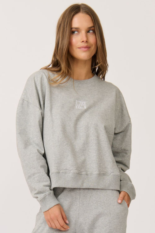 model wears a grey crew sweater