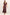 A woman modeling a long, dark plum maxi dress with a subtle plaid pattern, flutter sleeves, and a V-neckline, standing against a plain off-white studio background.