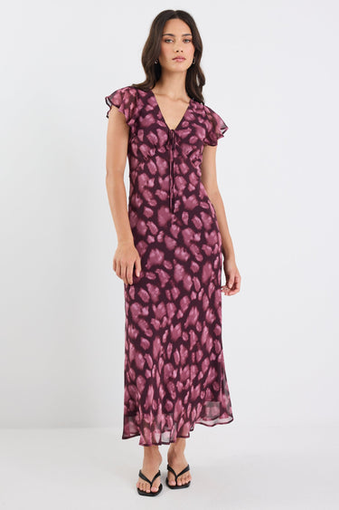 Woman wearing a purple floral dress on a white background