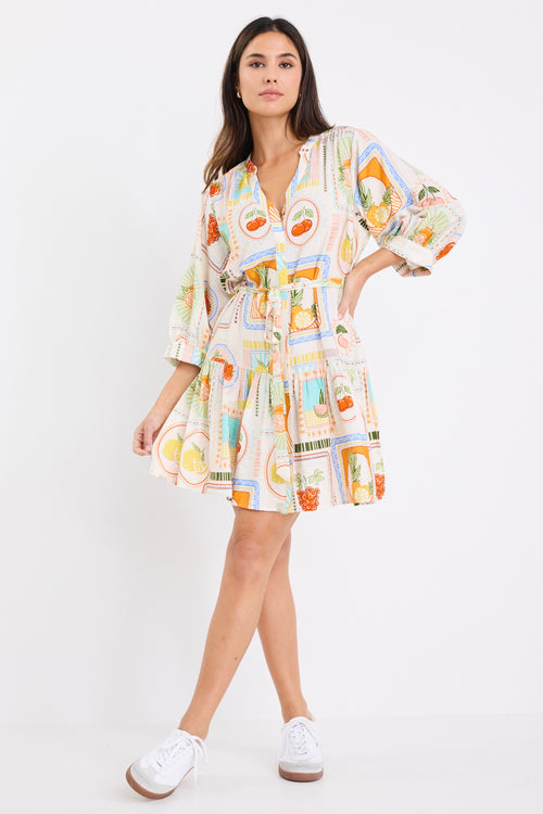 model wears a cream fruit print mini dress